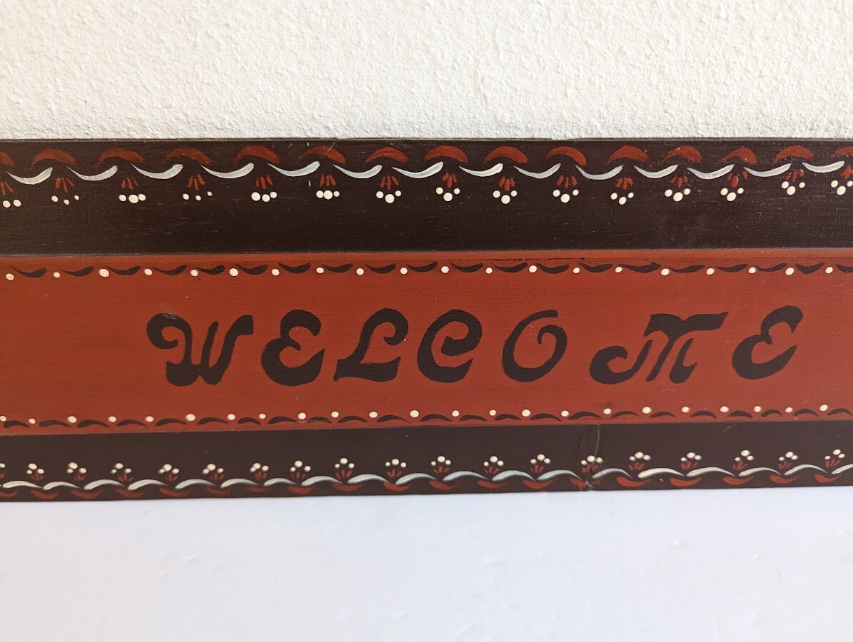 ‘Welcome All’ Folk Art Sign 24″ x 6″ Burgandy / Red Wall Hanging